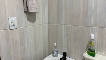 Secador de cabelo, toalhas de banho, sabonete, papel higiênico
