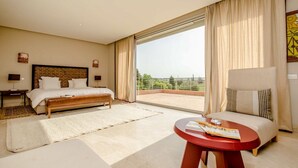 A hotel room with a bed, a sofa, a coffee table, and a balcony with a view. - Villa Ziram - Four Bedroom Villa, Sleeps 8 (Sidi Youssef Ben Ali)