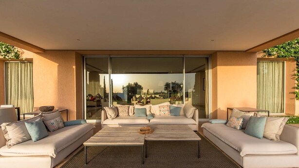 A modern outdoor living area with two sofas, a coffee table, and a glass door leading to a patio. - Villa Ziram - Four Bedroom Villa, Sleeps 8 (Sidi Youssef Ben Ali)