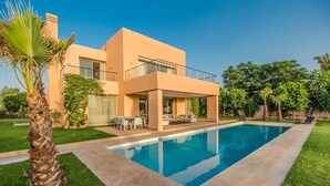 A modern two-story house with a swimming pool, outdoor furniture, and lush greenery. - Villa Ziram - Four Bedroom Villa, Sleeps 8 (Sidi Youssef Ben Ali)