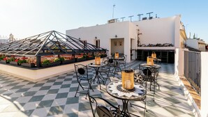 A rooftop terrace with checkered flooring, outdoor seating, and potted plants. - Argote 5 - One Bedroom Apartment, Sleeps 4 (Sevilla)