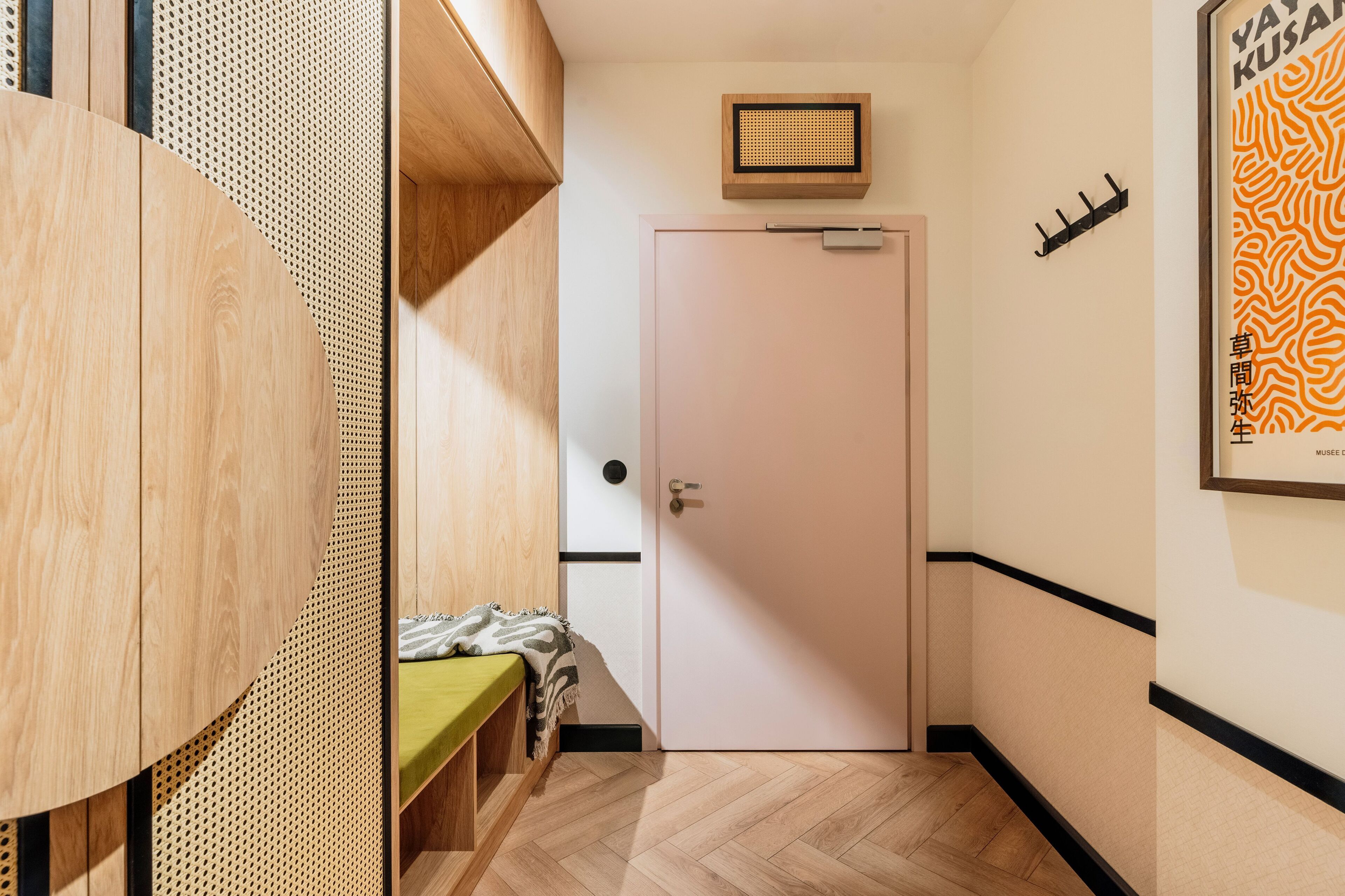 A hallway with a wooden bench, a door, and a wall-mounted light fixture.