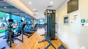 A modern gym with treadmills, ellipticals, and weight machines. - Elegant 1B Stunning Views & Balcony Business Bay (Dubai)