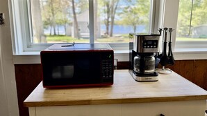 Eine Küche mit Mikrowelle und Kaffeemaschine auf einer Holzausziehtisch.
