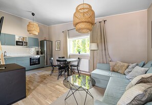 A modern kitchen with a dining area, a sofa, and a coffee table. - Comfortable Minihouse Vega (Trangsund)