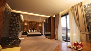 A modern hotel room with a large bed, a dining table with pastries, and a view of the city through the window. - Wedcation by Tivoli, Israna (Israna)