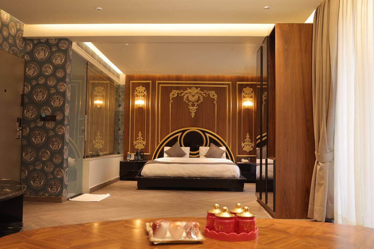Un dormitorio amplio con una cama grande, piso de madera y un panel decorativo.