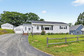 A residential area with a single-story house, a garage, and a small driveway.