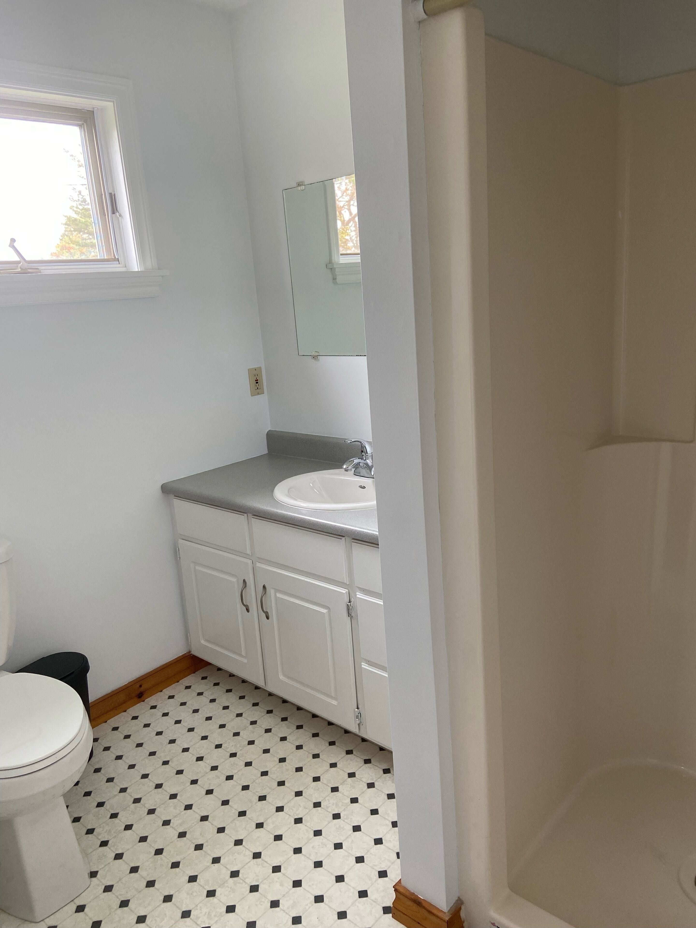A bathroom with a toilet, sink, and shower.