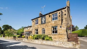 A stone building with a sign reading "Queens Head Inn." - Queens Head Inn (Harrogate)