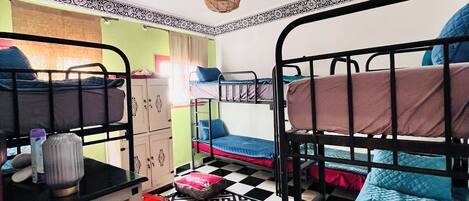 Un dormitorio con literas, un suelo estampado y una lámpara en el techo.