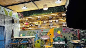 Un café animé aux murs en bois, orné d’une fresque murale, et proposant différents types de sièges, notamment des tables et des chaises.