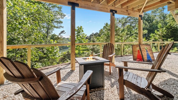 Een terras met houten stoelen en een vuurkorf.