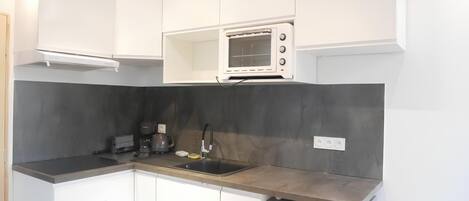 Een koelkast, een oven, een kookplaat, een waterkoker