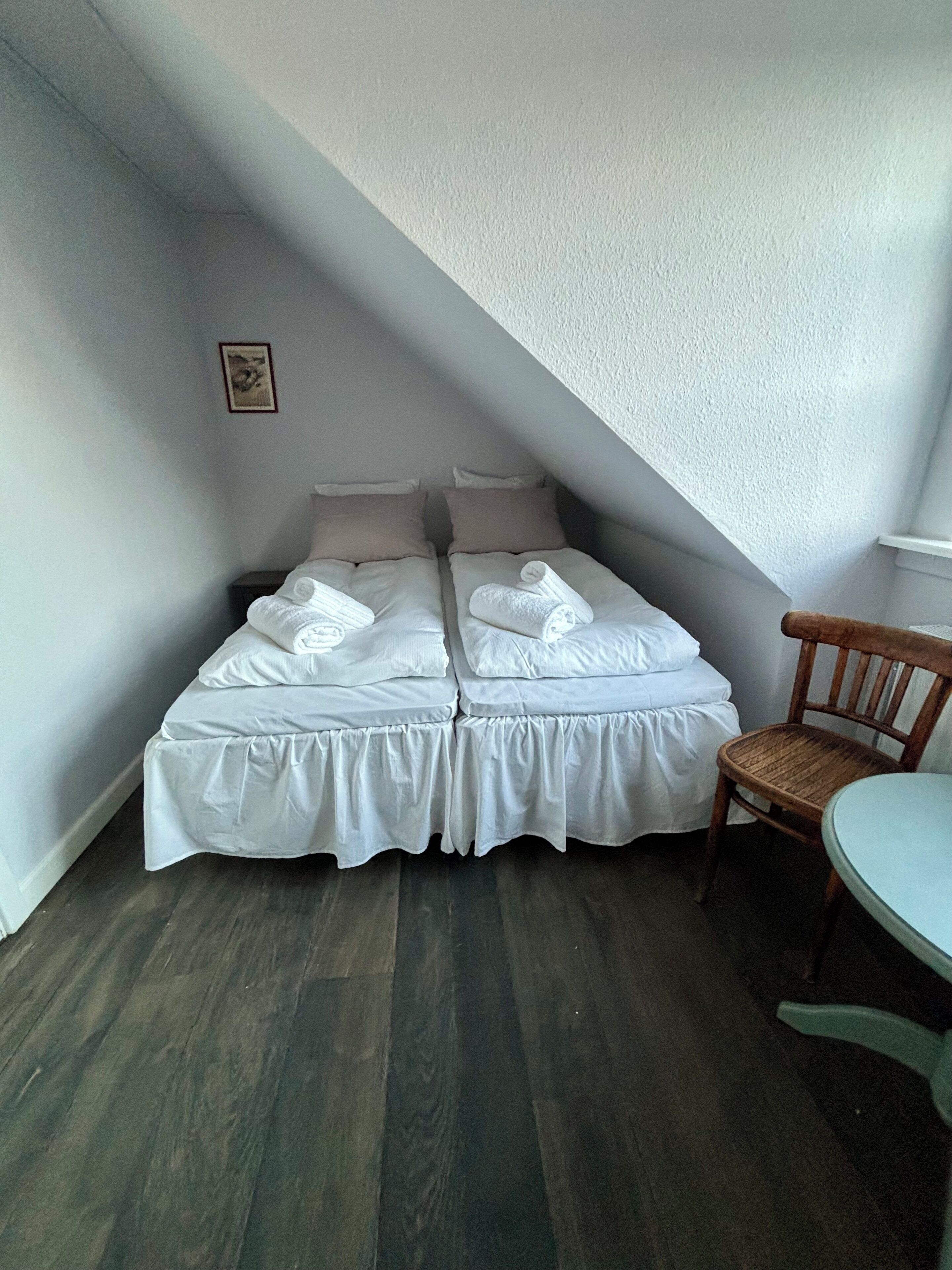 A room with a bed, a chair, and a small table.