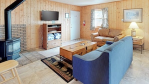 Ein gemütliches Wohnzimmer mit Kamin, Sofa und Fernseher.