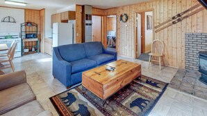 Ein gemütliches Wohnzimmer mit einem blauen Sofa, einem Holztisch und einem Kamin.