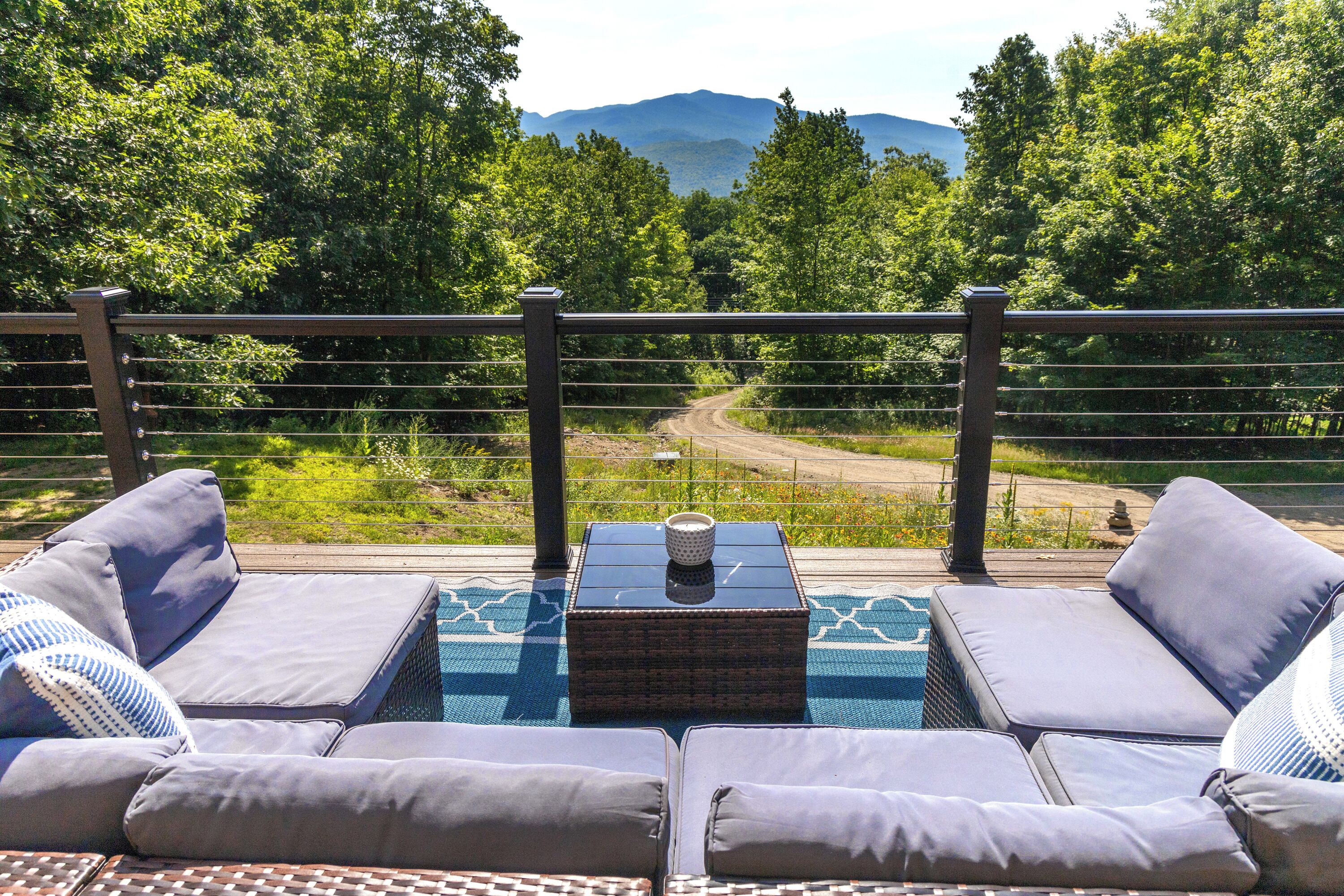 A balcony with outdoor seating and a view of a mountain.