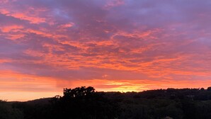 Un atardecer sobre un área boscosa con cielo despejado.