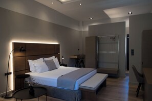 Une chambre d’hôtel moderne équipée d’un grand lit, de tables de chevet, d’un bureau et d’une armoire.