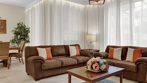 A living room with two sofas, a coffee table, a lamp, and a plant.