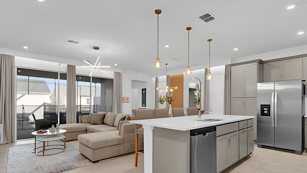 A modern kitchen with a central island, stainless steel appliances, and pendant lighting. - Dream Home at Solara Resort 6BD and Total Comfort (Kissimmee)