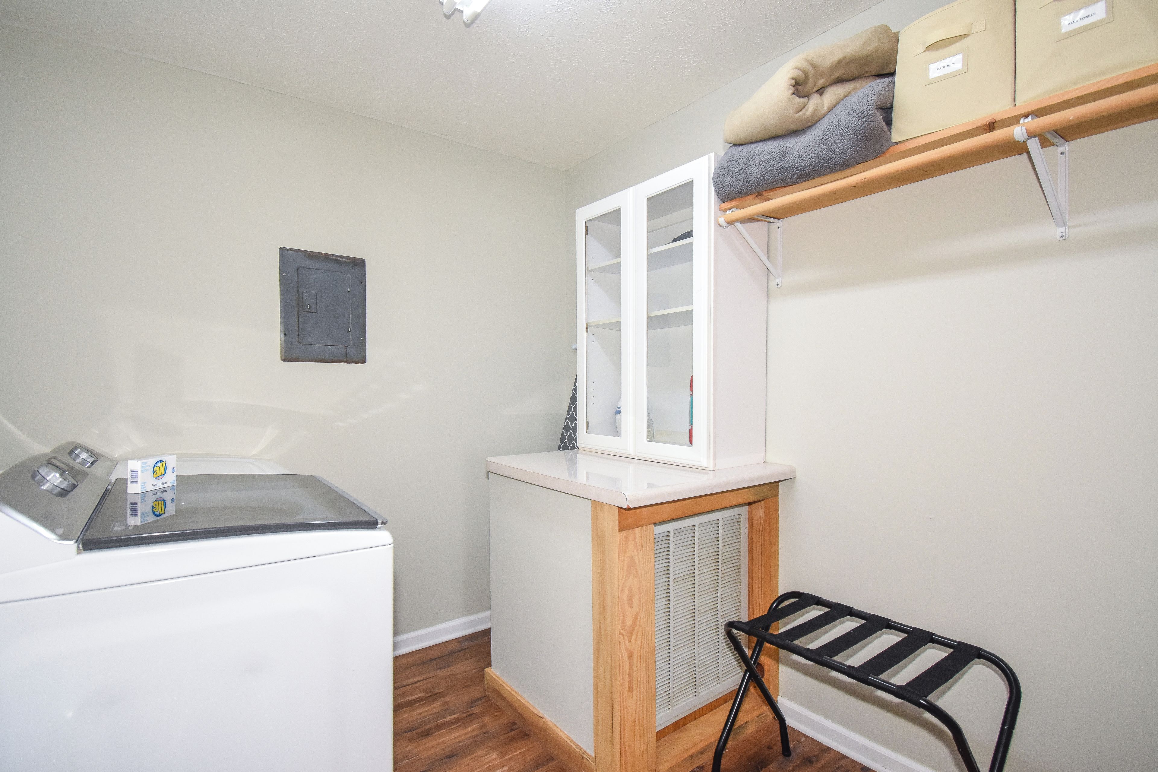 A laundry area with a washing machine, a dryer, and a small cabinet.