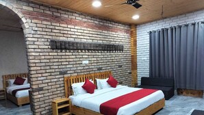 A modern bedroom with a brick wall, a wooden bed, a small bedside table, and a grey curtain.