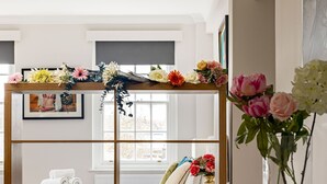 A modern hotel room with a wooden partition, a glass table, and a view of the city. - 4-bdr Stunning Kensington Penthouse (London)