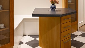 A kitchen with wooden cabinets, a black countertop, and a vase with flowers. - 4-bdr Stunning Kensington Penthouse (London)