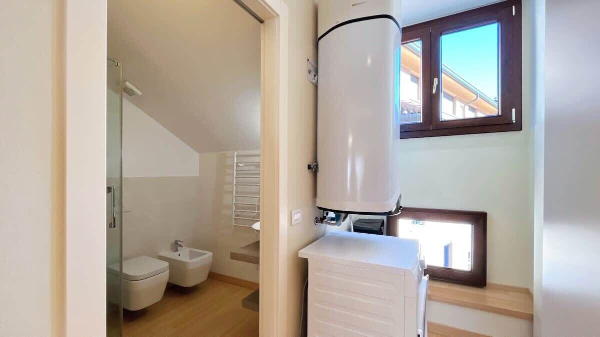 A bathroom with a toilet, bidet, and a water heater.
