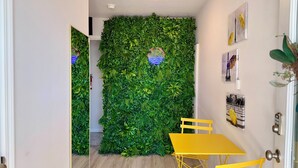 Ein Zimmer mit grüner Wand, gelben Stühlen und einem kleinen Tisch.