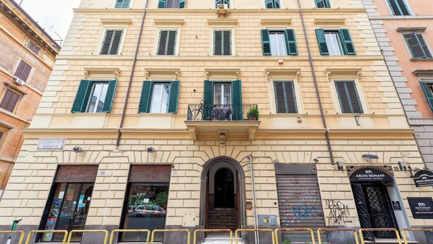 A multi-story building with a central entrance, balconies, and a sign for "Arch Romani Restaurant." - Whiteten Rome Apartment (Roma)