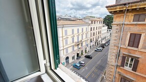 A street view from a window overlooking a row of historic buildings with a clear sky. - Whiteten Rome Apartment (Roma)