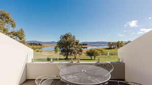 A balcony with a metal table and chairs, overlooking a lake and distant hills. - Horizons - 418/10 Kosciuszko Road (Jindabyne)