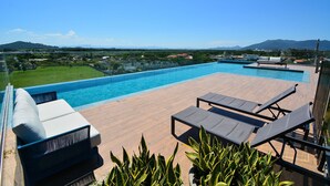 A rooftop pool area with lounge chairs and a view of the surrounding landscape. - Studio Shopping OKA Floripa - Campeche - SOK125 (Florianópolis)