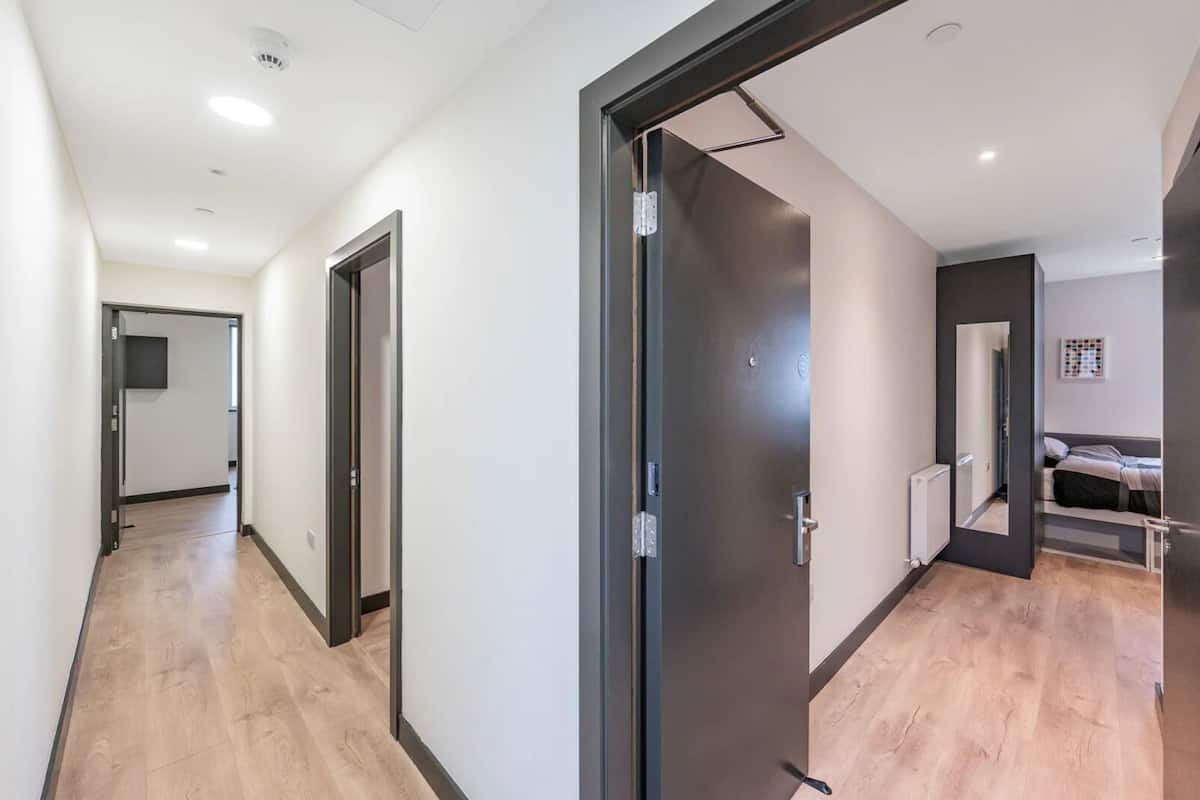 Een modern appartement met een gang die naar een slaapkamer leidt.