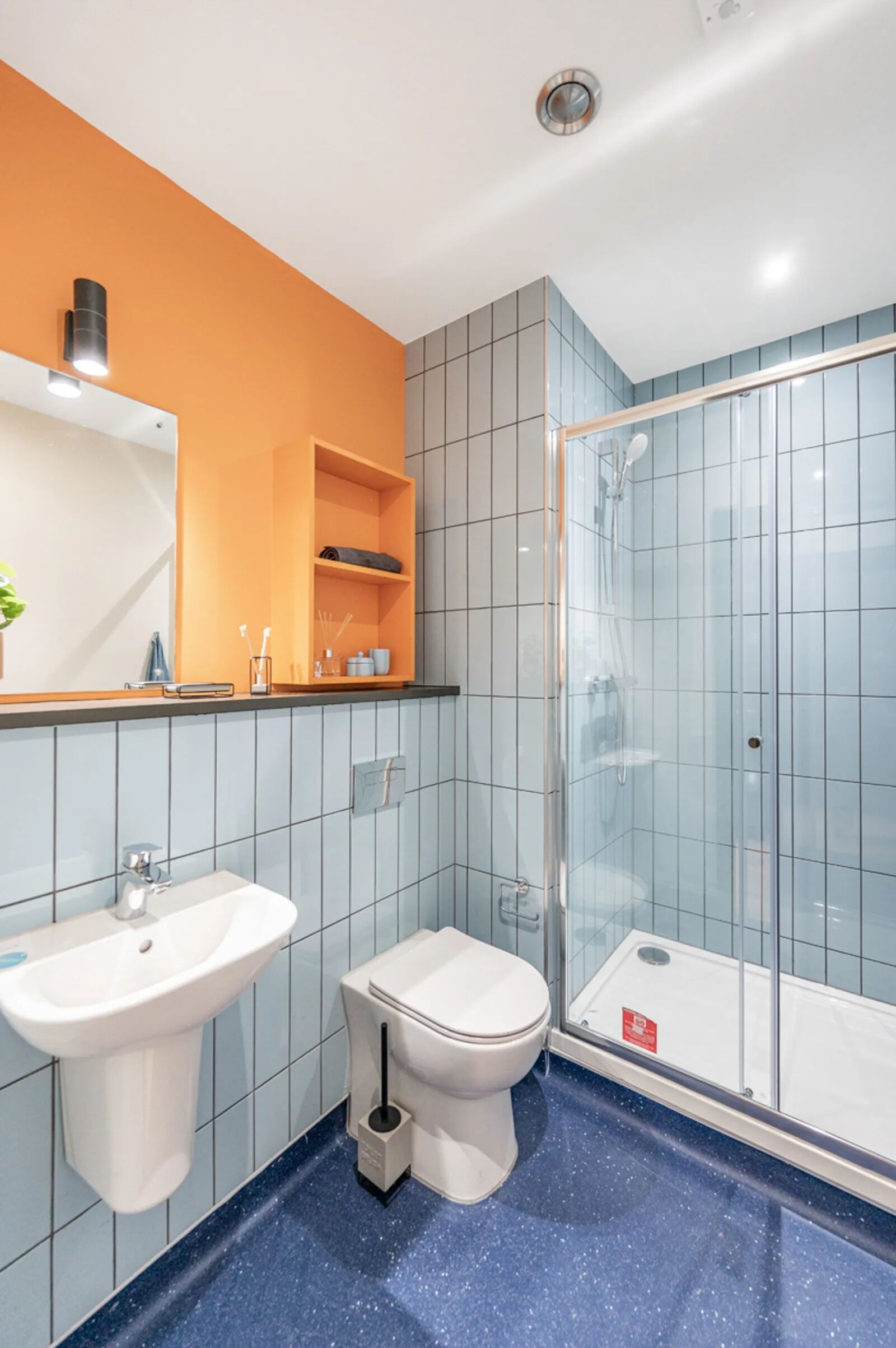 A bathroom with a sink, toilet, and glass shower enclosure.