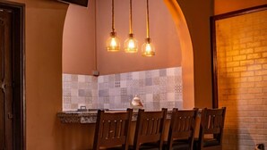 Un espace repas avec un mur en briques, un pare-feu en carreaux et un luminaire suspendu.