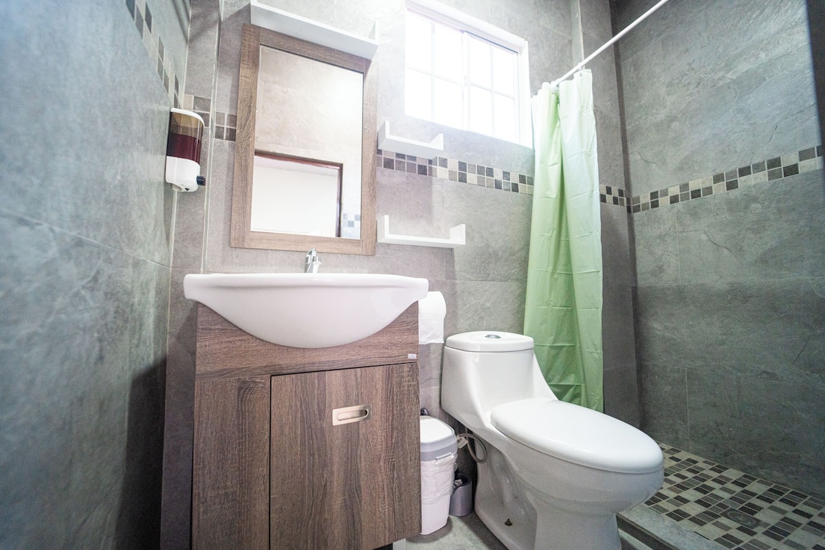 Een badkamer met een wastafel, spiegel en toilet.
