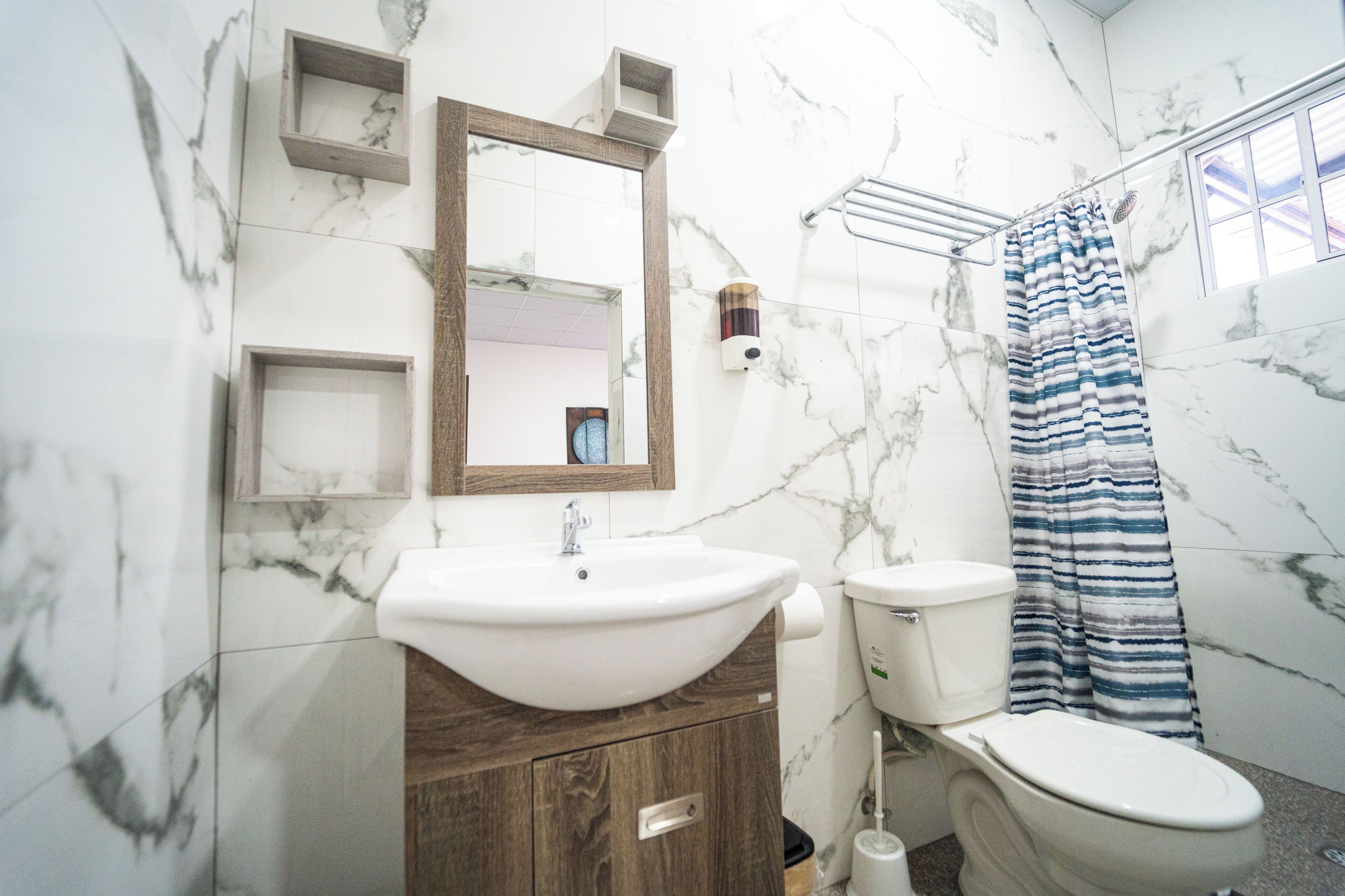 Quarto básico | Banheiro | Chuveiro, toalhas de banho, sabonete, papel higiênico