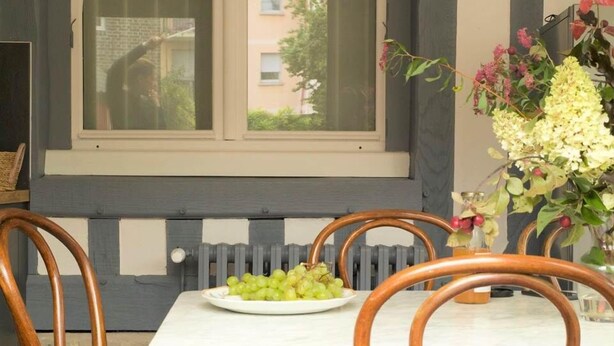 Un coin repas comprenant une table et des chaises, une fenêtre et un radiateur.