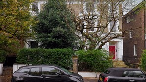 A residential street with two parked cars, a large tree, and a historic building with a red door. - Chic 1-Bed Flat w/Terrace in Notting Hill W10 (London)