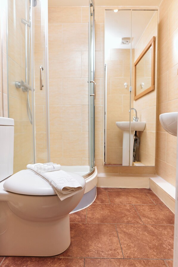 A bathroom with a toilet, shower, and sink. - Chic 1-Bed Flat w/Terrace in Notting Hill W10 (London)