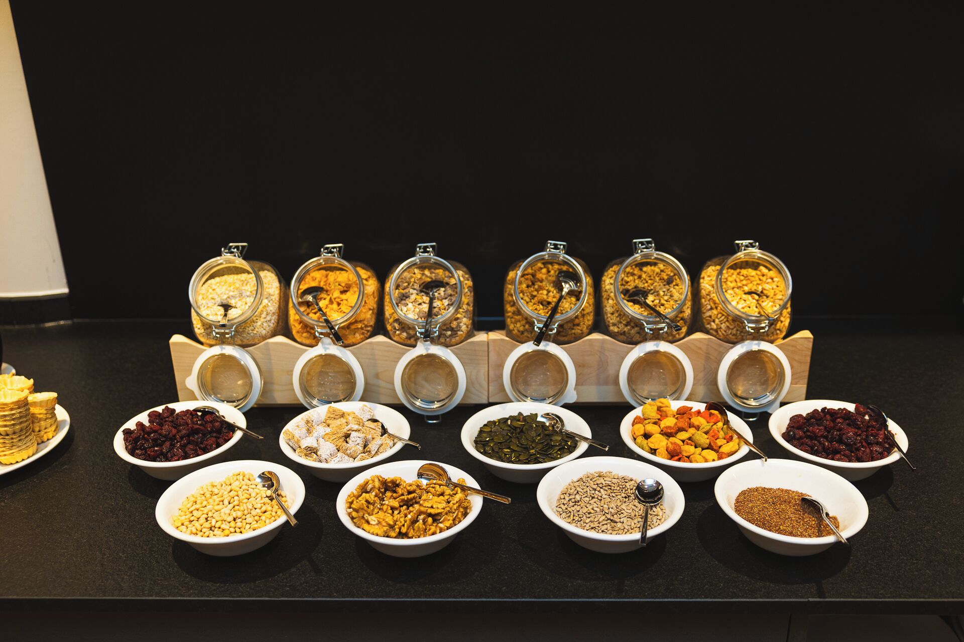 A variety of food items displayed in bowls and jars, likely in a buffet setting.
