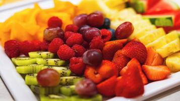 Eine Auswahl frischer Früchte, darunter Erdbeeren, Himbeeren und Kiwi-Scheiben.