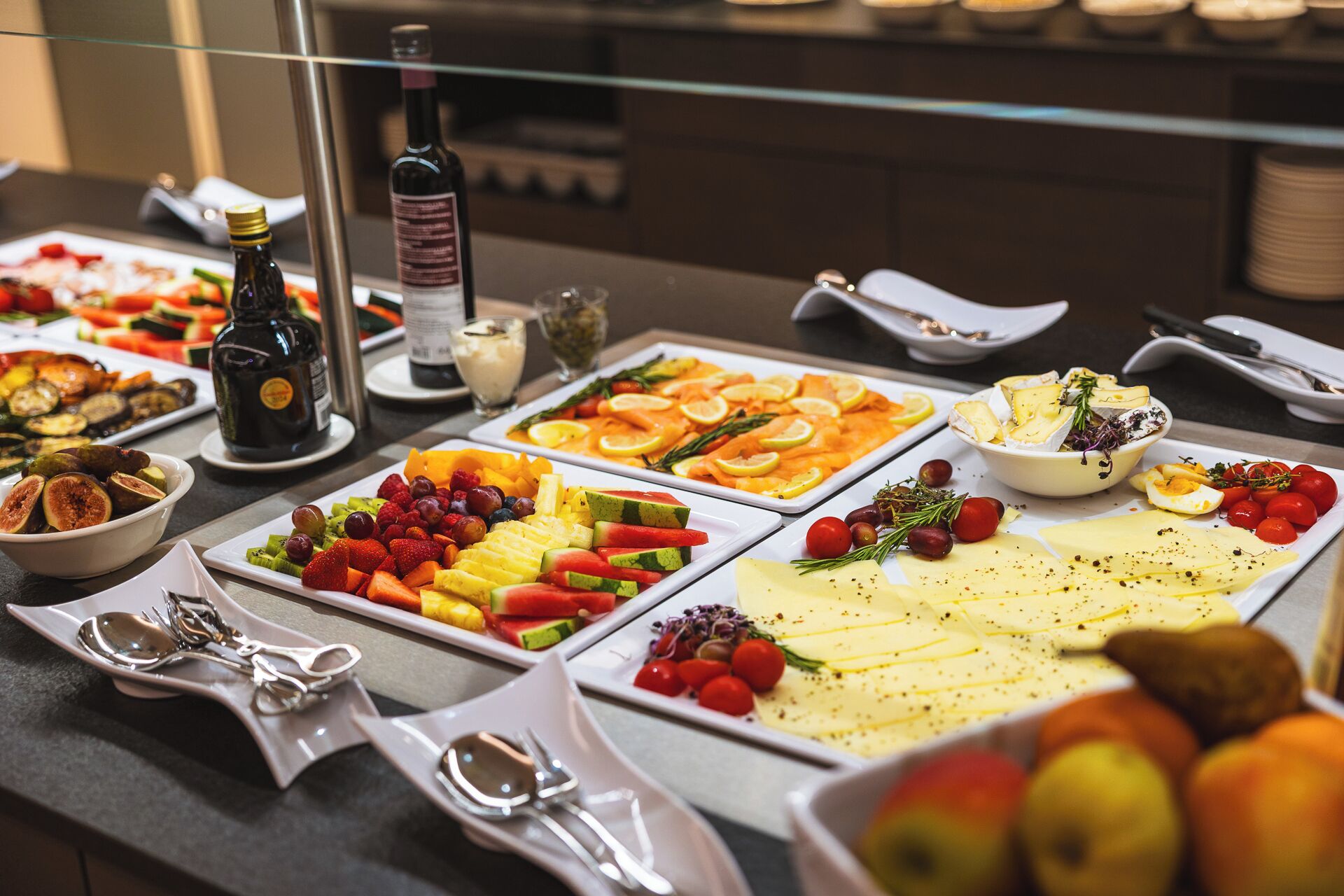 Un bufé con diversas opciones de comida, como frutas, quesos y ensaladas.
