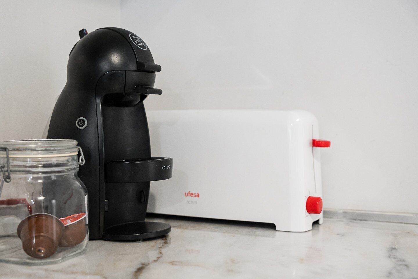 Eine Kaffeemaschine und ein Toaster auf einer Marmorarbeitsplatte.