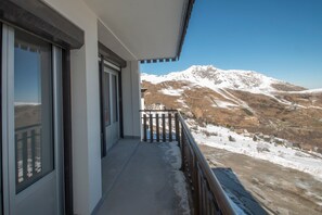 A balcony with a view of snow-covered mountains.