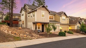 Une maison d’habitation à deux étages, dotée d’un porche à l’avant, d’une allée et d’un jardin paysager.